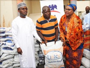 L-R, Director, Health and Nutrition, Dangote Foundation Dr. Azeez Oseni presenting food items to the Representative of Old Peoples Home Abuja Dr. M. Ifeyinwa Obegolu, assisted is the Representative of the Minister of Federal Capital Territory, Mrs. Elegbede Irene Adebole, when the Dangote Foundation officially presented the food items to the needy in Abuja.