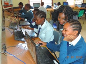 Photo Caption:  Faraja Nyalandu assists a school girl using Shule Direct platform. 